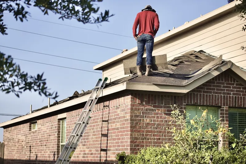 Professional roofer working on a residential roof in Oldham Village